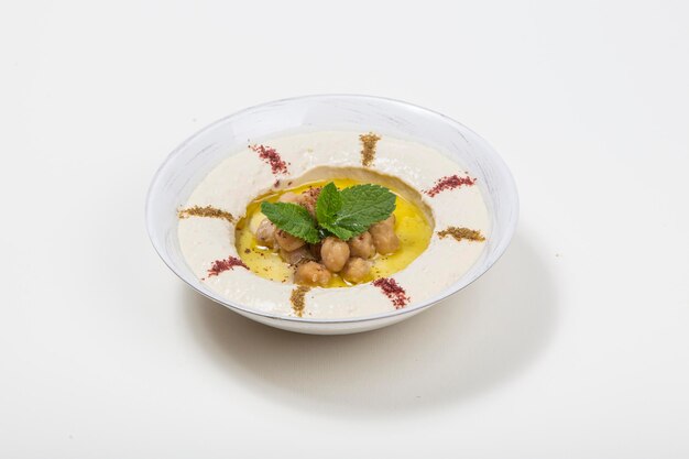 Photo chickpea hummus garnished with fresh menth and olive oil paprika o white background