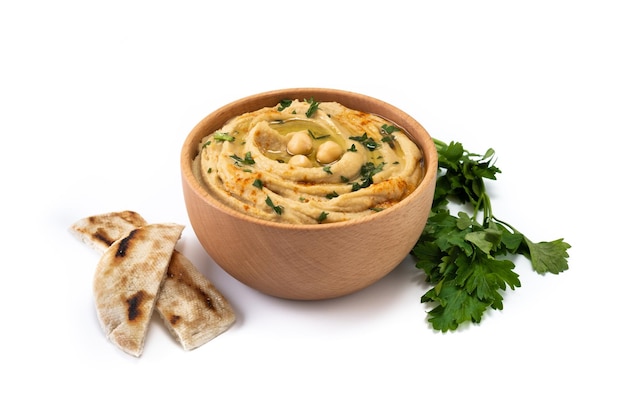 Chickpea hummus in a wooden bowl garnished with parsley paprika and olive oil