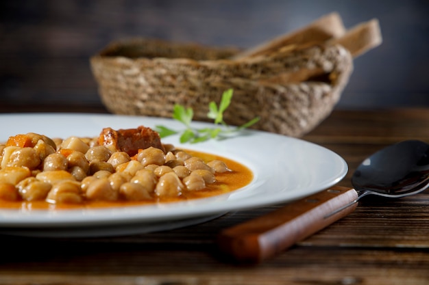 Chickpea stew dish, cocido madrileÃÂ±o. With beef, sausage (chorizo), bacon, carrots and bread.