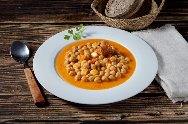 Chickpea stew dish, cocido madrileÃÂ±o. With beef, sausage (chorizo), bacon, carrots and bread.