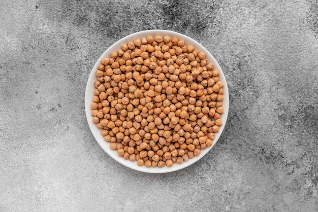 Chickpea in a white saucer on a gray concrete background