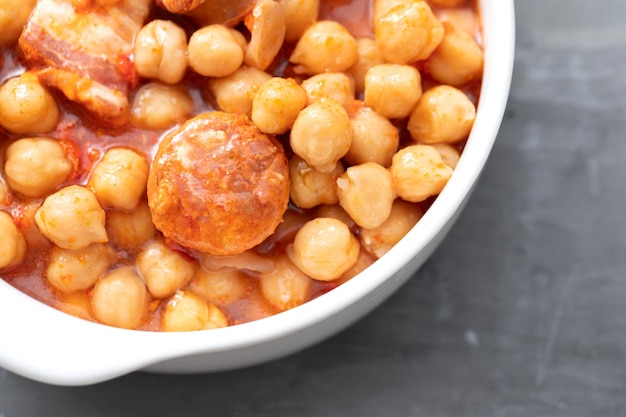 Chickpea with smoked sausage in white bowl