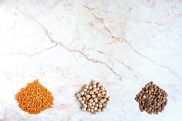 Chickpeas and two sorts of lentil on a marble background