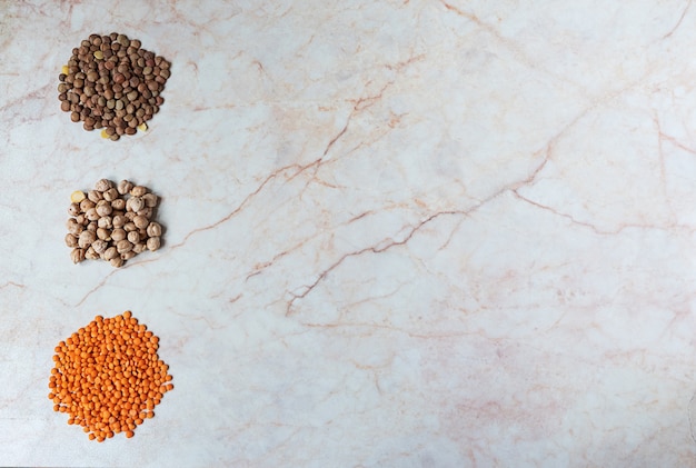 Chickpeas and two sorts of lentil on a marble background