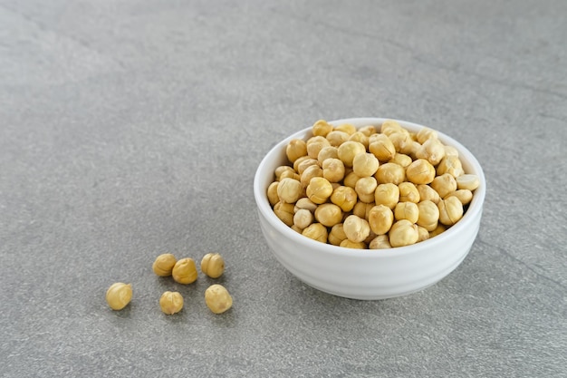 Chickpeas in white bowl on grey background Space for text