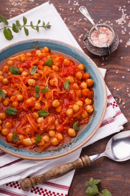  Chickpeas with tomatoes, decorated with mint