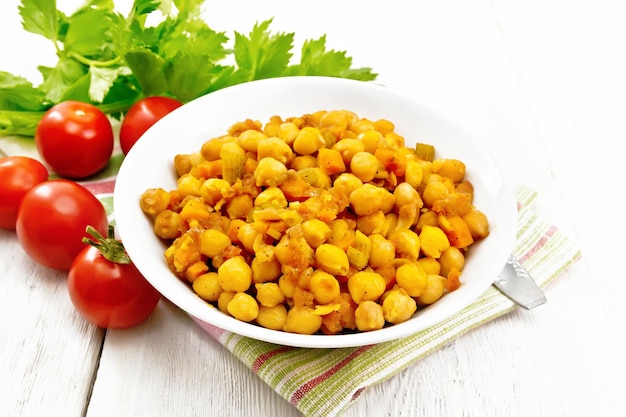 Chickpeas with vegetables stewed in plate on board