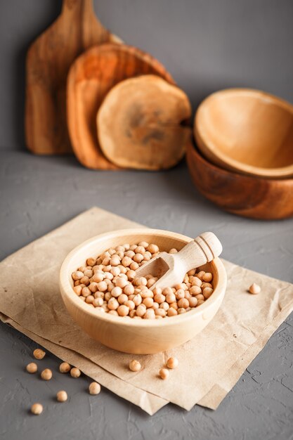 Chickpeas in a wooden bowl on gray background