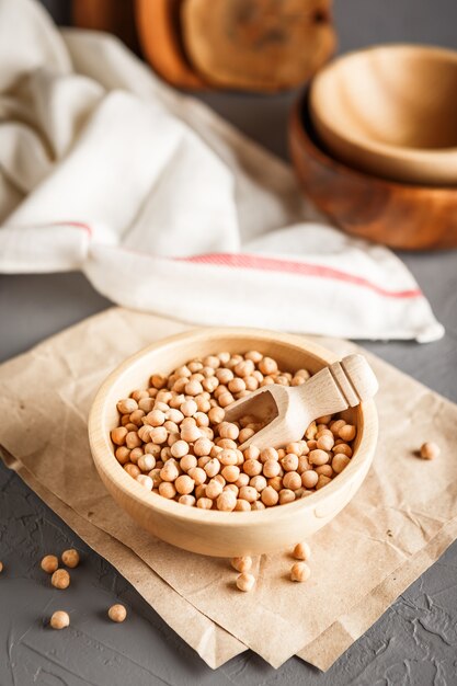 Chickpeas in a wooden bowl on gray background