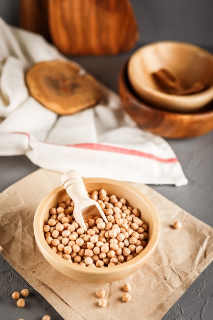 Chickpeas in a wooden bowl on gray background