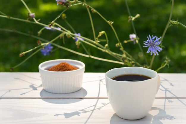 Chicory in a mug on a wooden table with hard light