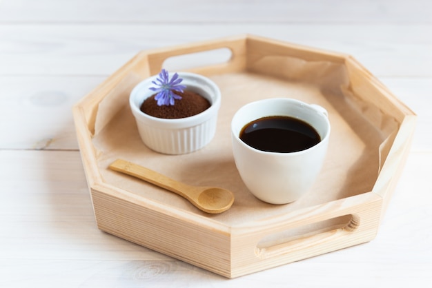 Chicory in a mug on a wooden tray.