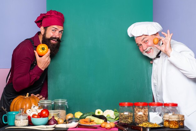 Chief cook Blackboard menu copy space Looking out of cardboard sheet chef cook thumbs up