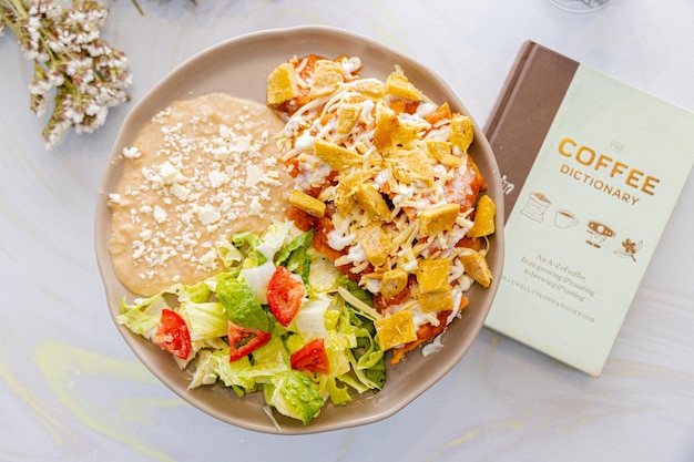 Foto chilaquiles met gepureerde bonen en salade