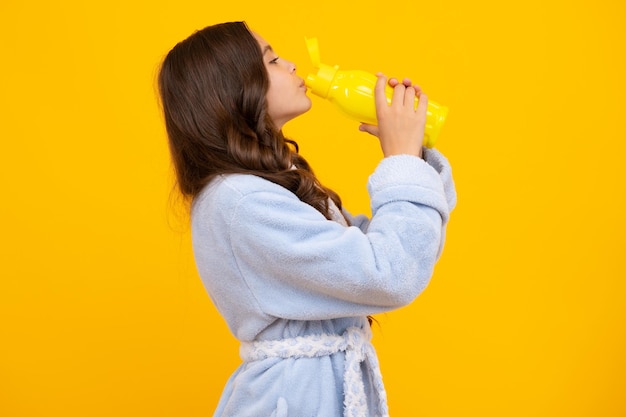 Photo child 12 13 14 years old with water bottle isolated on yellow background water bottle and healthy life health and water balance