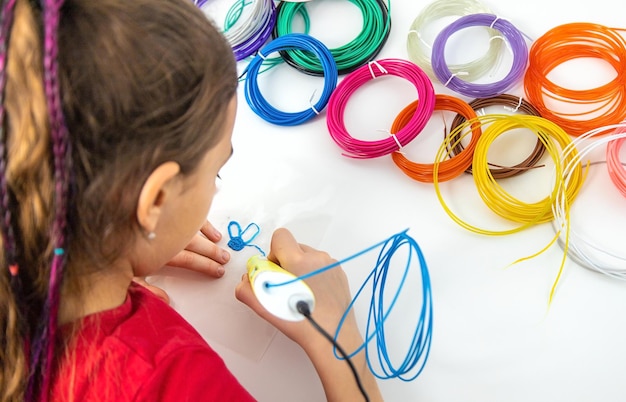 Child 3D drawings with a pen on the table Selective focus