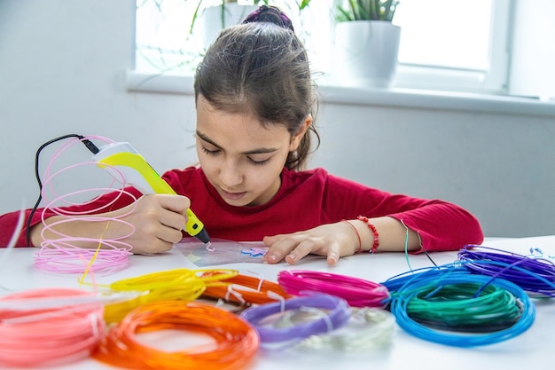 Disegni 3d del bambino con una penna sul tavolo fuoco selettivo