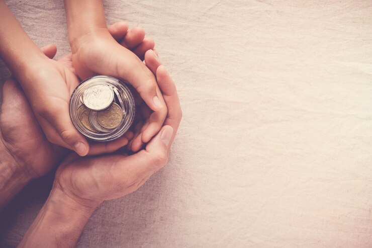child and adult holding money jar, donation, saving concept
