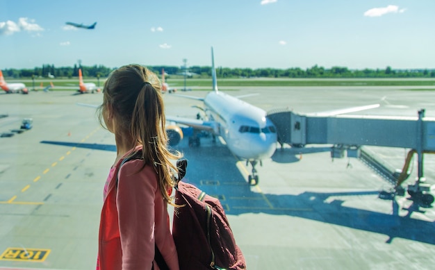 A child at the airport looks at the plane. Selective focus. Kid.