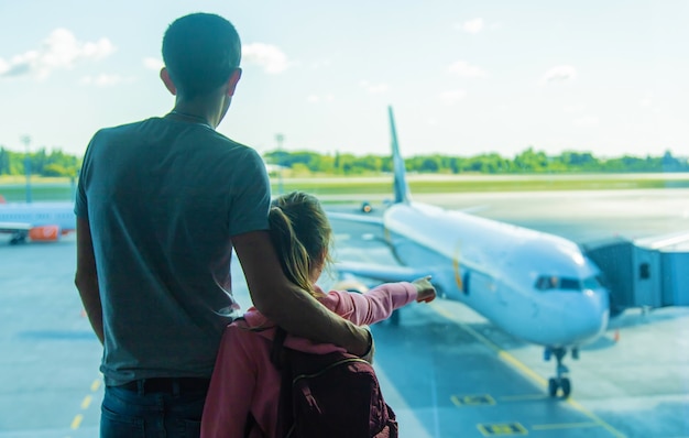 A child at the airport looks at the plane. Selective focus. Kid.