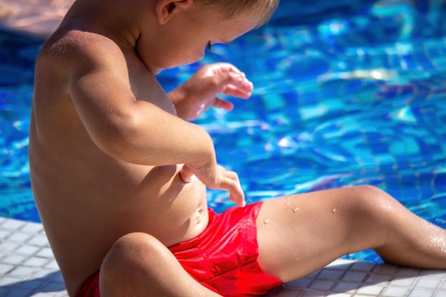 A child applying sunscreen to his stomach