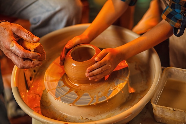 Child of the art of making a pot or a vase of clay. 