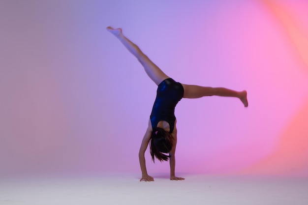 child athlete gymnast performing gymnastic exercises on the floor training for competition