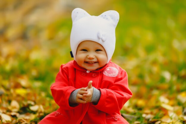 Child in autumn foliage takes its first steps