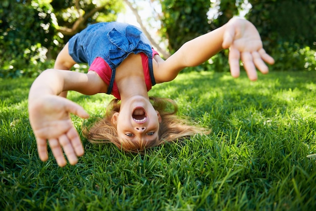 Foto bambino schiena e piega o ponte per giocare in estate o gioco di flessibilità o pratica divertimento o cortile bambino faccia e mani o ginnastica allungamento con la testa equilibrio sull'erba a londra felice o giardino