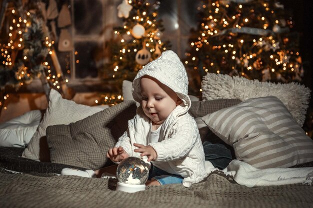 child on the background of a decorated Christmas tree