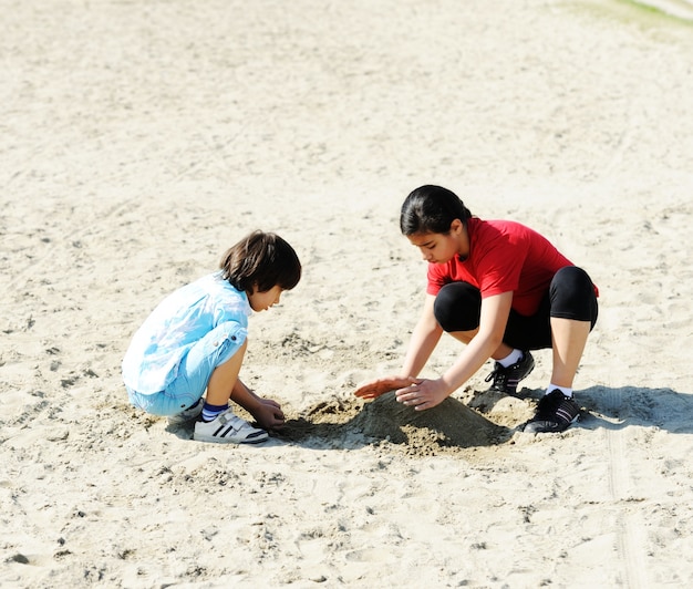 Bambino sulla spiaggia a giocare con la sabbia