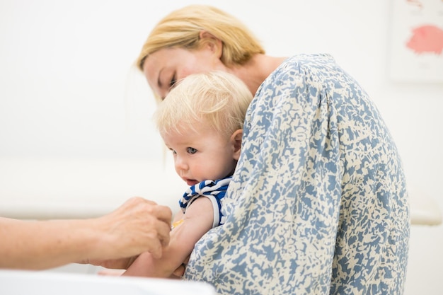 母親の立ち会いの下、小児科医からワクチン接種を受ける子供 ディップに対する予防ワクチン接種