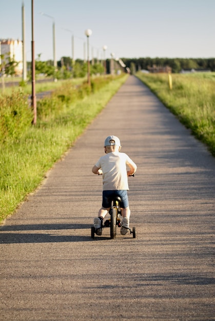 Foto un bambino in bicicletta in città un ragazzo percorre una strada ciclabile