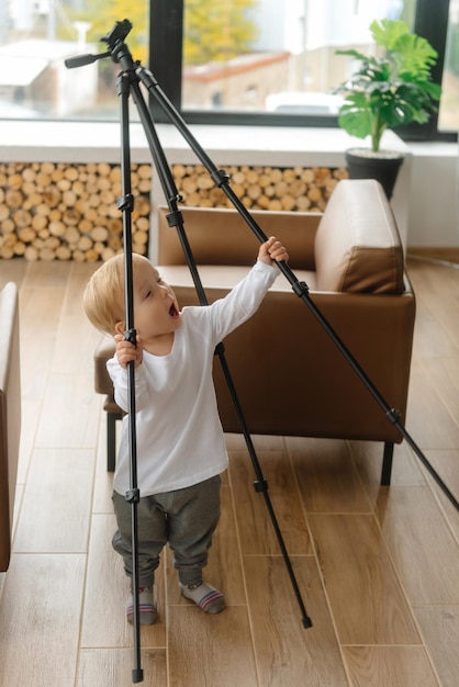 Foto un bambino blogger tiene in mano un treppiede video e si prepara a diventare un giovane blogger