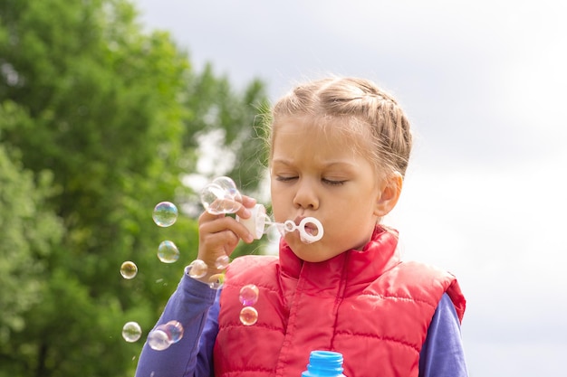 Child blowing bubbles in summertime