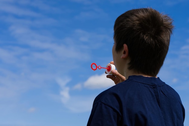 The child blows soap bubbles in nature