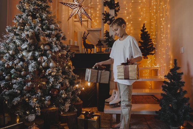 Child boy decorating Christmas tree at home. Family with kids celebrate winter holidays. Kids decorate living room and fireplace for Christmas.