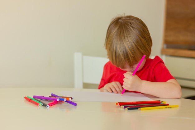 写真 子供の男の子はテーブルに座って鉛筆を描きます子供の娯楽レジャー活動教育ゲーム