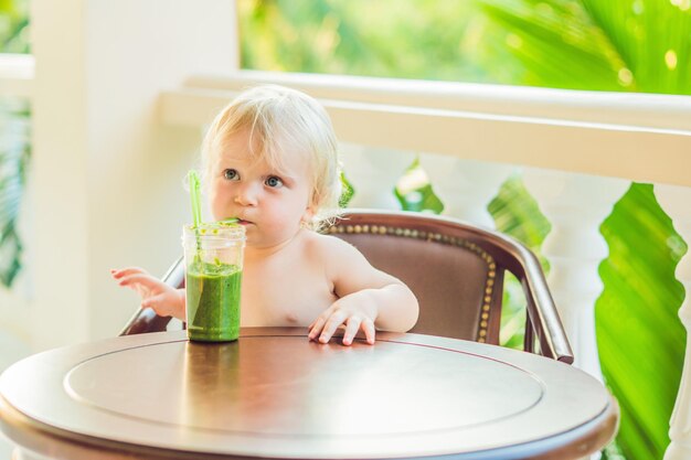 健康的な緑の野菜のスムージーを飲む子供の男の子-健康的な食事、ビーガン、ベジタリアン、有機食品と飲み物のコンセプト