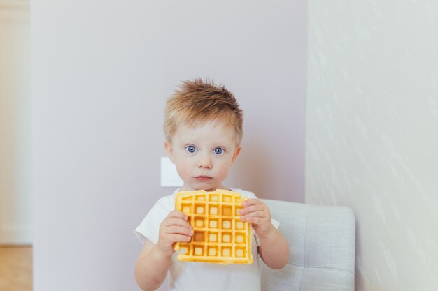 子供の男の子は、朝、自宅のキッチンで朝食を食べます