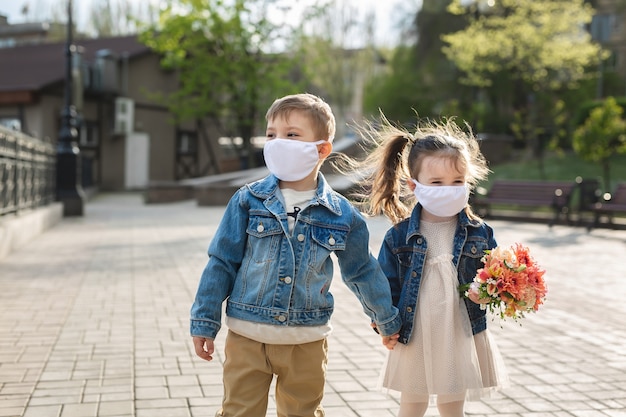 Child boy and girl walking outdoors with face mask protection. Coronavirus, covid-19