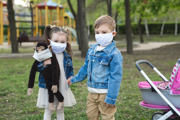 Child boy and girl walking outdoors with face mask protection