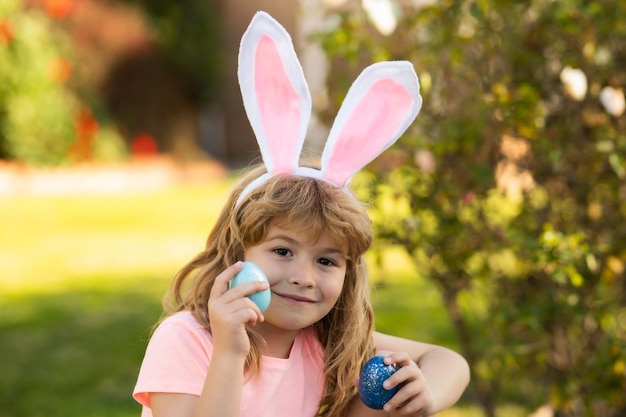 Child boy hunting easter eggs kid with easter eggs and bunny ears outdoor