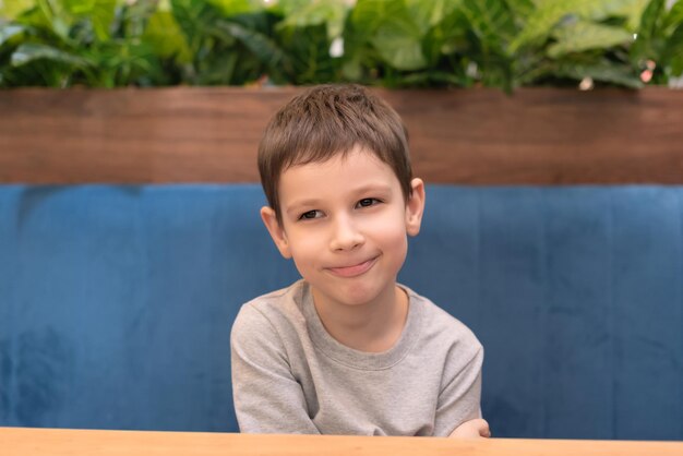 Child boy is waiting for his order in cafe