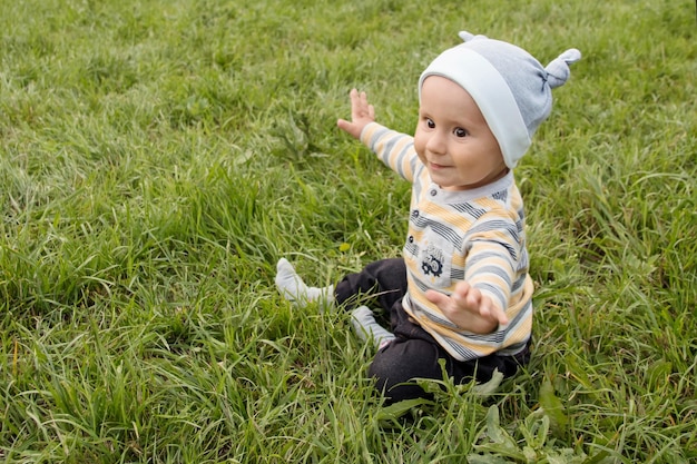 Фото Мальчик на траве летом маленький ребенок на прогулке