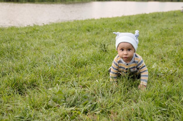 写真 夏の芝生の上の子供男の子散歩中の小さな子供