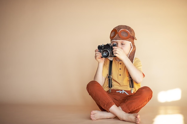 小学生くらいの男の子がカメラを手に持って写真を撮る