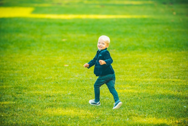 Child boy run in spring or summer field kid at park childhood activity leisure lifestyle concept