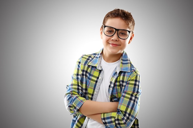 Child boy teenager with glasses on a gray background