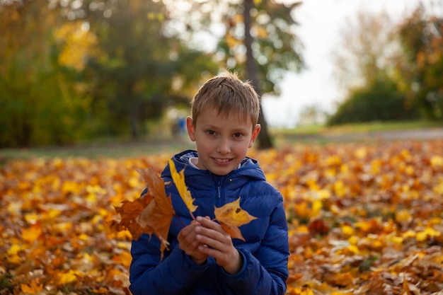 Мальчик гуляет в осеннем парке Осенние листья детская концепция